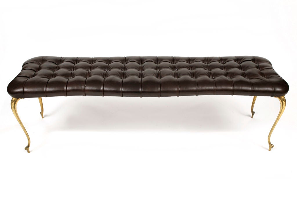 Subtly curved button tufted leather bench from Italy circa late 1950’s. Done in a richly grained chocolate brown leather with solid brass cabriolet legs. Excellent restored condition.