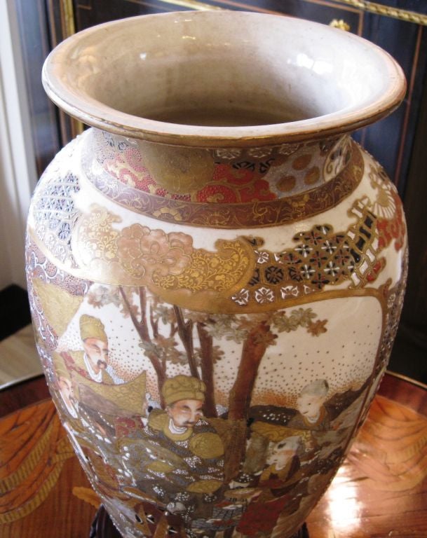 An intricately decorated Japanese 19th century Satsuma vase with figures and geometric designs.  Hand painted with raised applied dots, floral shapes, clouds and various textures all over. Primarily in rich earth tones with gilt accents over