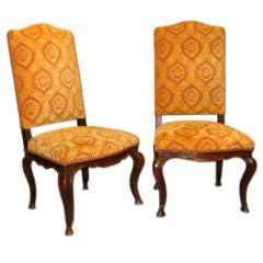 A pair of walnut chairs with cabriole legs and carved aprons