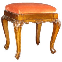 A carved walnut stool with apricot velvet upholstery