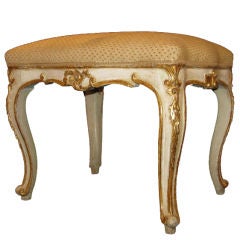A painted, carved and gilded wooden stool with cabriole legs.