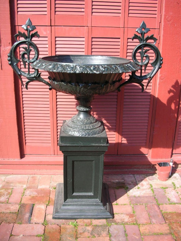 Cast Iron urn by J W Fiske, the exuberent handles attached to the ornate body decoarted with leaves and anthemions, raised on an elaborate socle, all on a plinth base. Signed, J. W. Fiske 21 & 23 Barclay St. NY