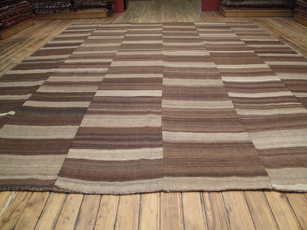 A large tribal floor cover. It is double layered and features a different color and pattern on each side. Both sides can be used.