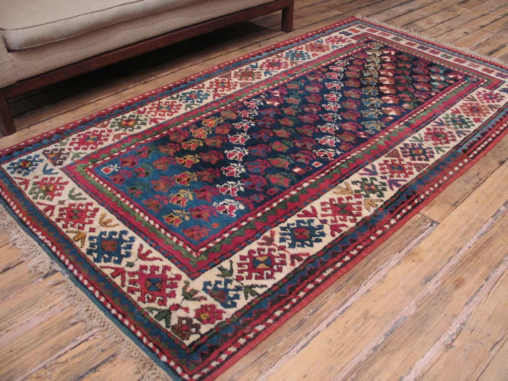 Antique Gendje/Kazak rug. A handsome antique Caucasian rug with glowing colors and whimsical detail - such as the sudden change in the design and width of the border at the bottom of the rug.