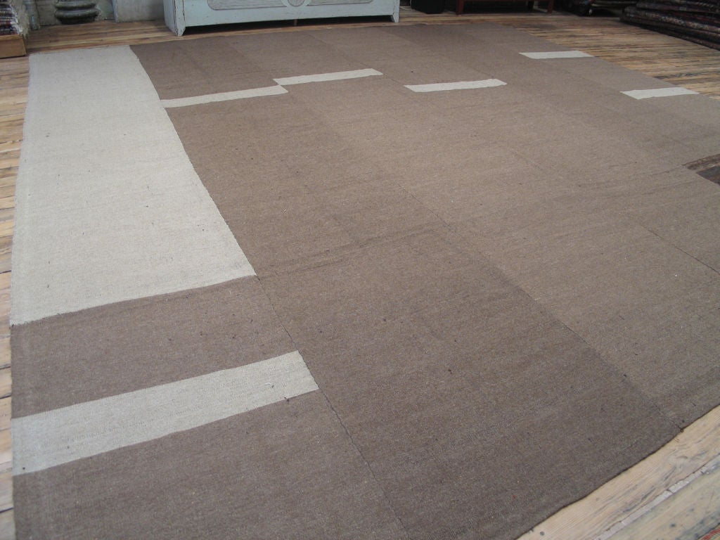 A tribal floor cover woven with un-dyed, natural, hand-spun wool. The rug consists of six panels, woven on a narrow loom, pieced together with simple stitching. Wonderful texture, contemporary feel.