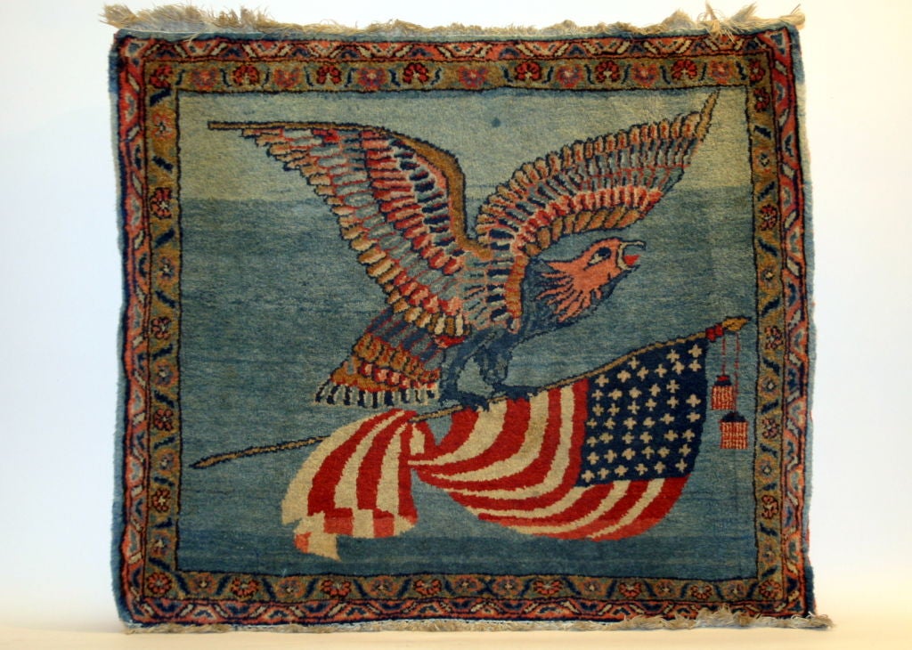 Antique Persian Kashan carpet featuring an American bald eagle grasping an American 44 star flag. In 1891, one star was added to the US Flag, representing Wyoming, bringing the total number of stars to 44. The thirteen stripes represent the thirteen