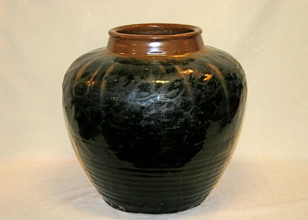 Large antique Chinese coil formed storage jar paddled into uniformity. Yuan or Ming dynasty, 13th/14th century. Brown over black glaze. 17