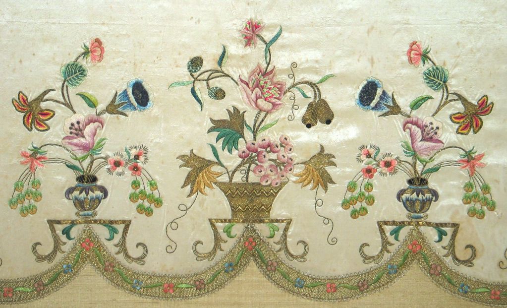c. 1770's English  silk  embroidered apron on off white silk taffeta, exquisitely embroidered in polychrome silk threads  with images of  floral urns.  Scalloped edges are finished with lace embroidered metallic trim. Mounted.