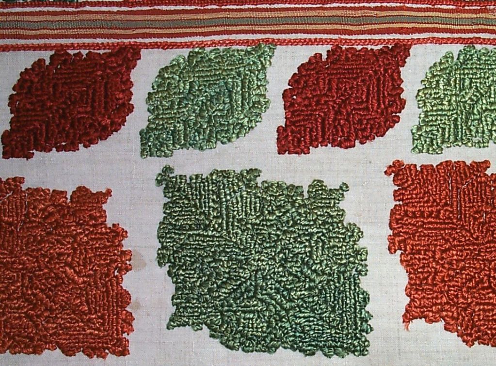 18th century embroidery from Rhodes, Greece, with geometric designs in red and green silk on a natural linen ground.