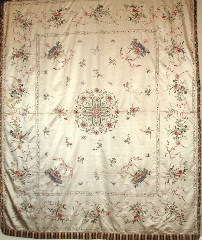 19th century Chinese export (Macao) champagne colored silk bed cover embroidered in polychrome silk threads in designs of floral sprays, floral baskets, and a central floral motif.  The colors are soft salmon, coral, blue, and green.