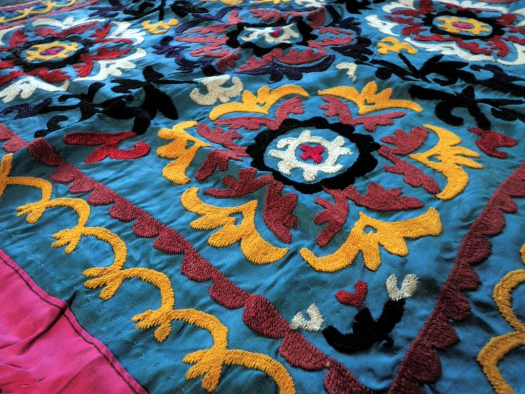 A very colorful, small, vintage, embroidered Suzani from Uzbekistan.  Beautiful blue background.