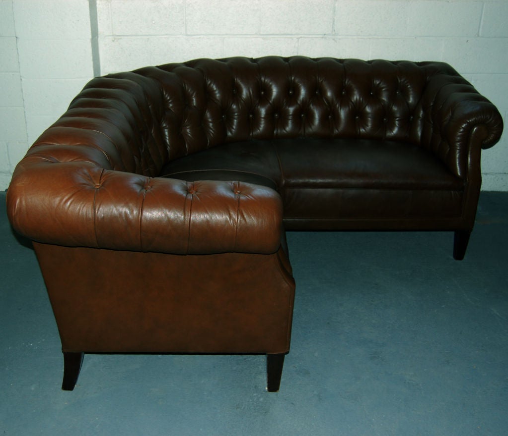 Unusual corner sofa in the button-tufted Chesterfield style.  Upper/tufted portion covered in a soft deep brown leather and seat in a thick, more durable cow hide - in almost the same color - barely noticeable from each other.  Small triangular