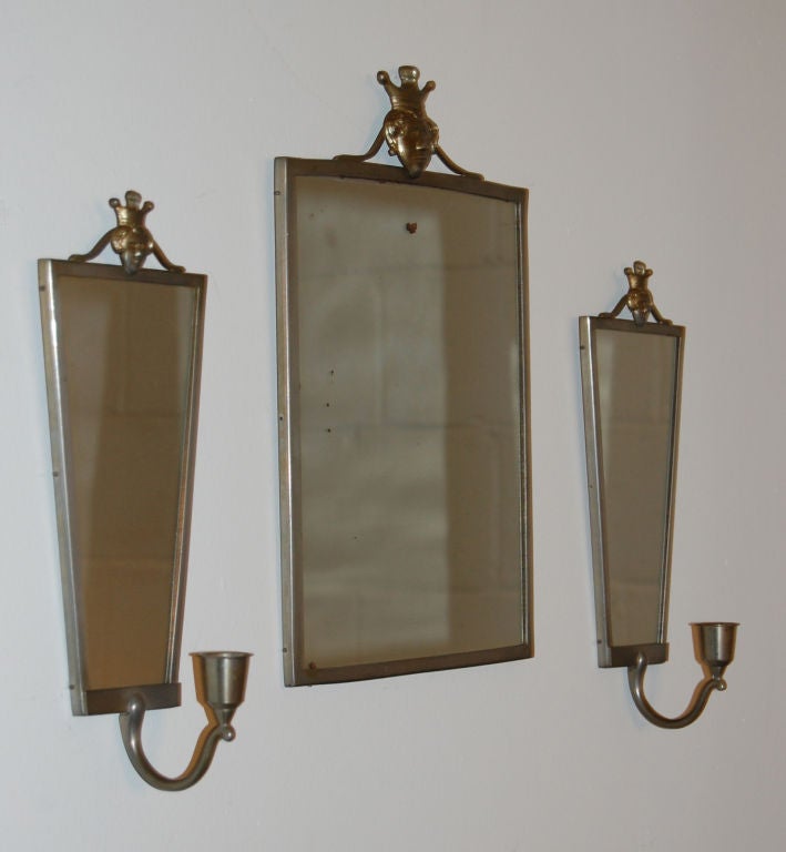 Vintage pewter mirror and mirrored candle sconces with crowned figure motifs by noted Swedish decorative arts firm Svensk Tenn.<br />
<br />
Mirror dimensions: 8 3/4