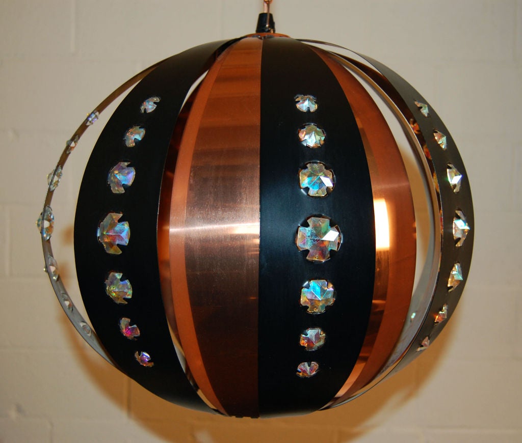 Magnificent round globe pendant created by alternating strips of copper and black metal accented with glass 