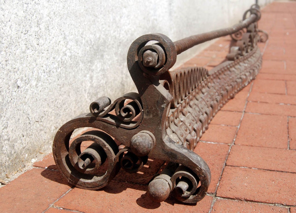 Very large and fine wrought iron fireplace fender from the Arts & Crafts era in late 19th century America. Twists, weaves and curlicues are patterns that have been worked into this example.