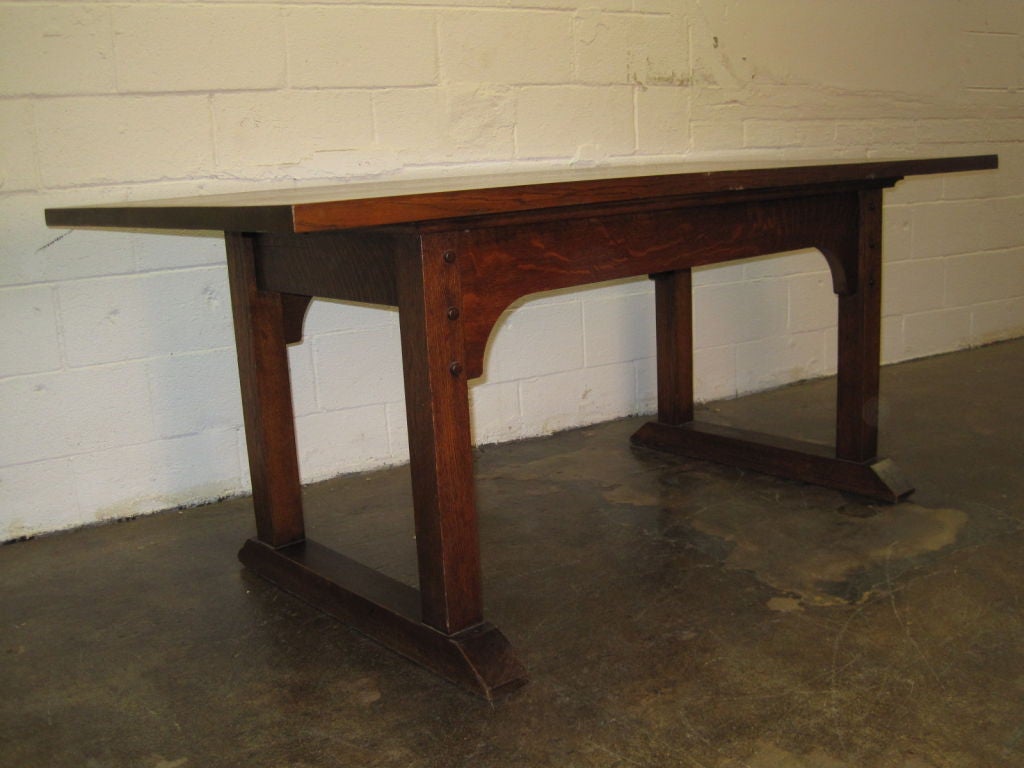 A Large stately Dining/Conference Table having a thick quarter sawn top and very large apron with a perfectly determined overhang.Large oak pegs at all corners and shoe feet make this wonderful table the rarest of all the Stickley forms.