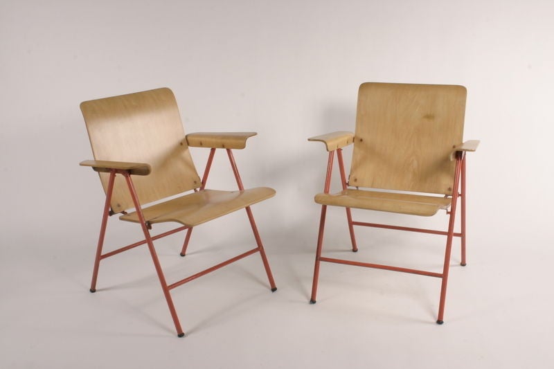 This is a wonderful set of 4 folding chairs by Russel Wright. 30.5h x 24.5w x 25.5d x 17h seat inches, plywood and salmon color enameled iron base, labeled at the bottom 