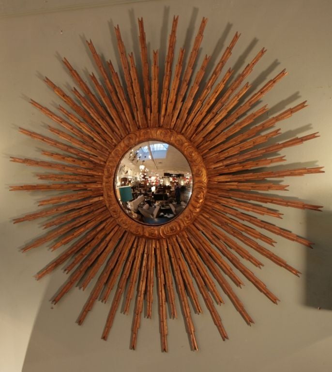 Spectacular large Spanish sunburst mirror in hand carved and gold leafed wood with original convex mirror.