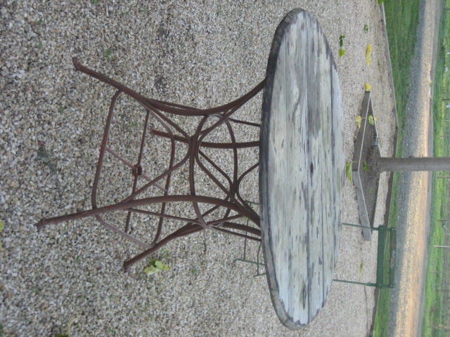 Vintage French table de jardin or wooden bistro table, c.1900. 

Wooden top previously had a hole for an umbrella and a red metal base. Vintage condition and minor wear consistent with age and use.
