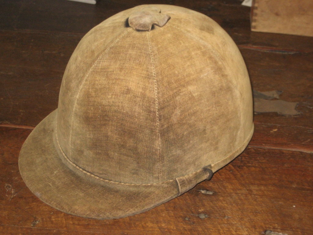 Vintage velvet riding hat from the 1930. The riding hat has a chin strap with a green stain lining. Tag reads The Triple Crown designed by Harry Hall, made in England.