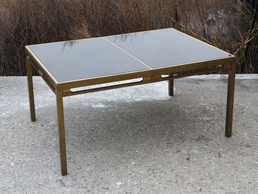 Exceptional, expandable 1970's brass and black glass dining table by Jansen with two drop-in leaves and pair of folding support legs.
Two 20