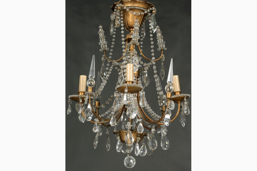Elegant Jansen crystal and brass four arm adorned with crystal finials, faceted drops and crystal garland.