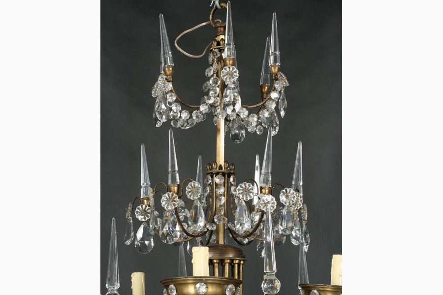 Impressive Jansen crystal and brass six arm chandelier with two tiers of faceted crystal spire finials and draped crystals. Circa 1930.