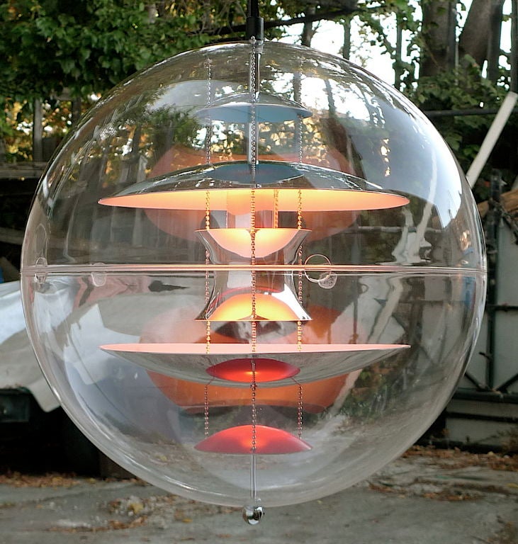 Unique and magical light terrarium comprised of a transparent acrylic globe containing suspended aluminum reflectors formed from hemispherical wedges lacquered blue and orange on one side and chromed on the other. Also available in larger 20