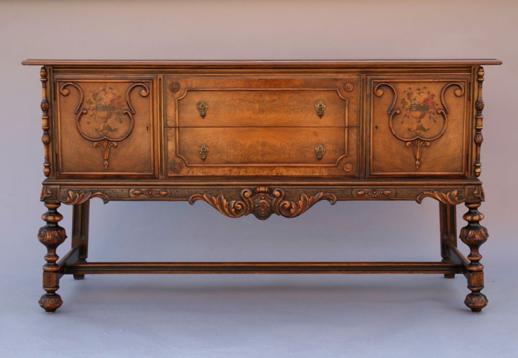 Hand-painted walnut sideboard by Berkey and Gay with two drawers and two cupboard areas for storage.  Features include many carved details, hand painted doors, and wonderful original hardware.