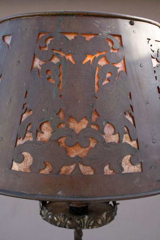 Incredibly detailed floor lamp with rare, ornate copper shade. Shade of incised cut-work copper over mica features various heraldic crests. Lions and unicorns are amongst the fauna flanking their respective shields. When unlit, the finely etched