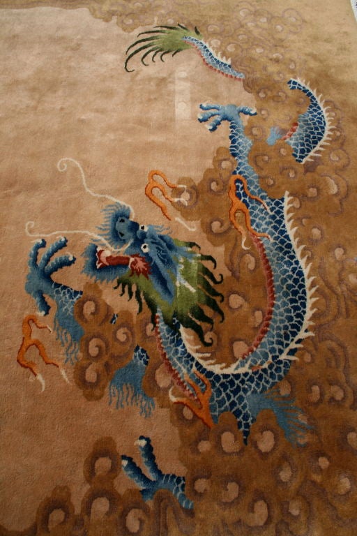 Dramatic and graceful scene of two fierce celestial and terrestrial dragons bordering a quiet, open field.  A beautifully balanced pictorial rug with soft earthy pallet  accented with rich blues and greens.  A strong and dramatic centerpiece for any