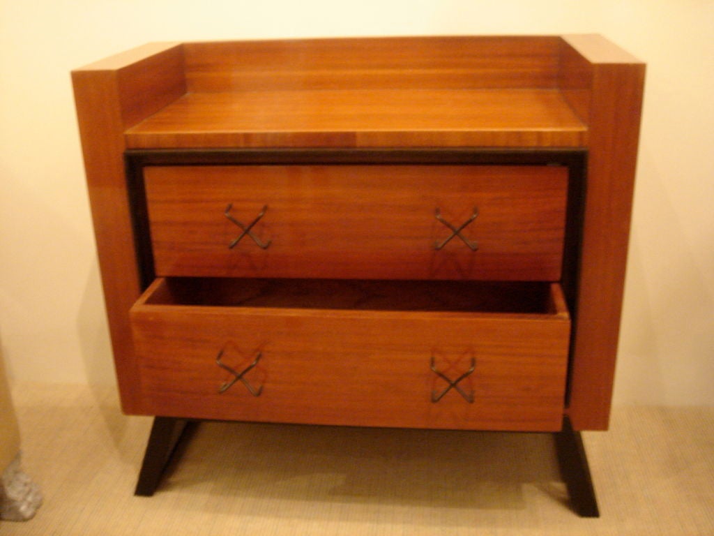 A chest of drawers designed by Jean Royere of very interesting form. The body of mahogany, the drawers surrounded by a frame of black patinated iron, to match the flaring foot. The handles of undulating cross form. Original drawing from Royere