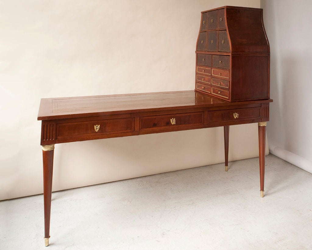 A Directoire mahogany , 3 drawers in apron, with a brown leather inset top, with a free standing cartonnier, Continental, late 18th century