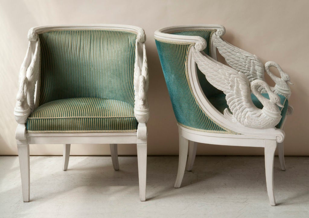 A pair of Empire style white painted chairs, carved swans on side, barrel back, French, 20th century