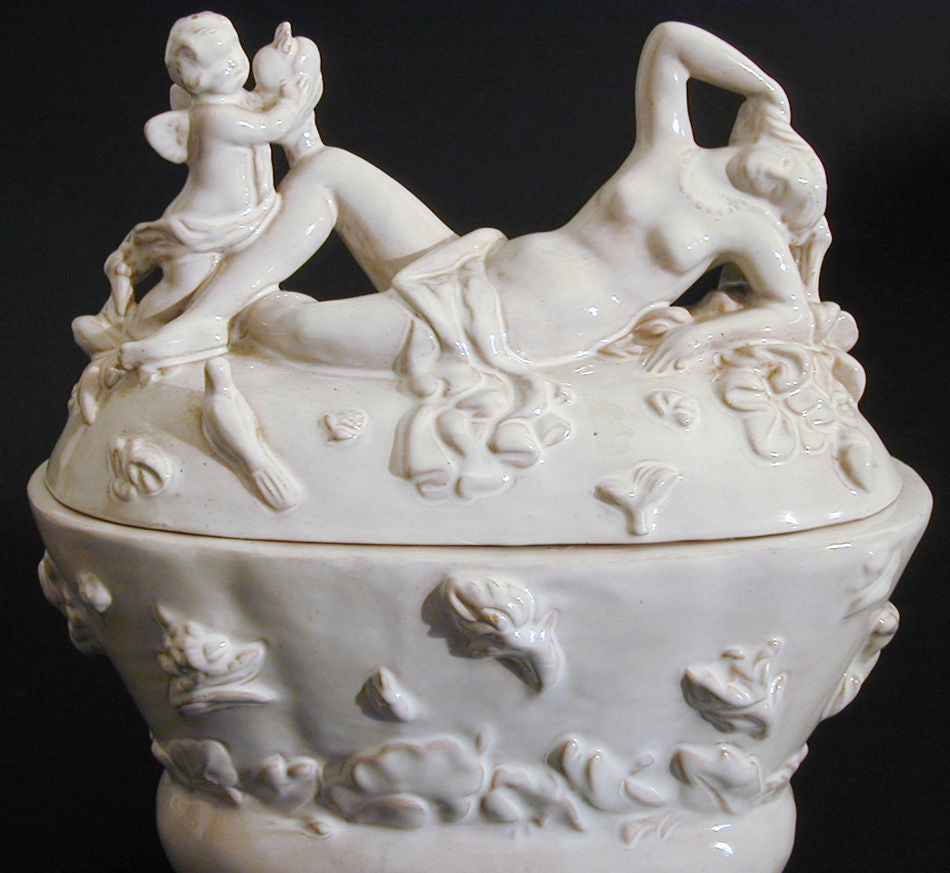 Affascinante e sensuale allo stesso tempo, questo vaso con coperchio finemente dettagliato che raffigura una figura di Venere nuda accompagnata da Eros è stato scolpito da Willi Russ per le ceramiche Karau di Vienna.  L'opera è ricca di dettagli e