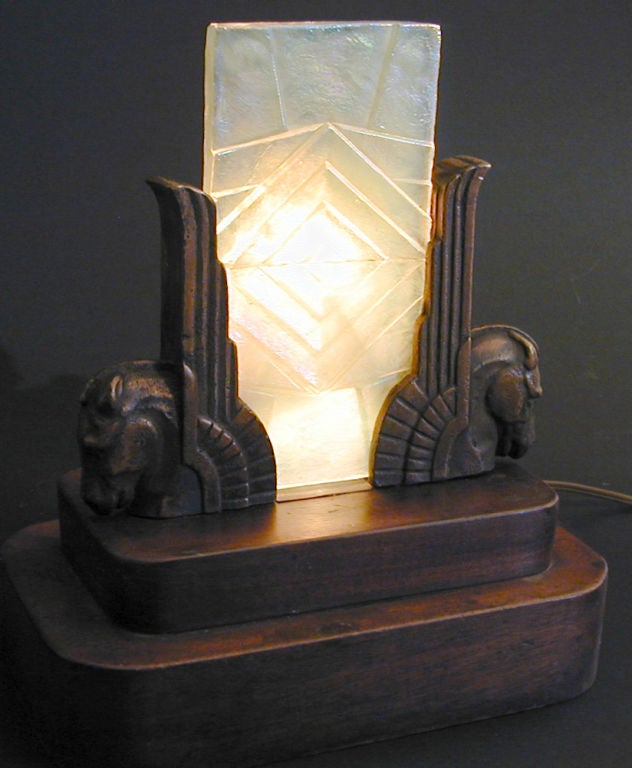 Rare and finely crafted, this very fine table lamp features a pair of bronze-finished winged horses flanking an Art Deco iridescent glass panel, strongly reminiscent of the glass produced by Tiffany until the late 1930s.  The lamp is mounted on a