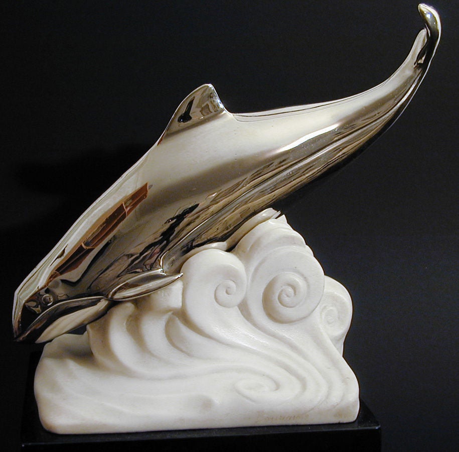 Elegant and quintessentially Art Deco in conception and execution, this elegant yet playful depiction of a whale diving into stylized waves is especially topical in an era when whales are both imperiled and beloved.  Sculpted of carved white and
