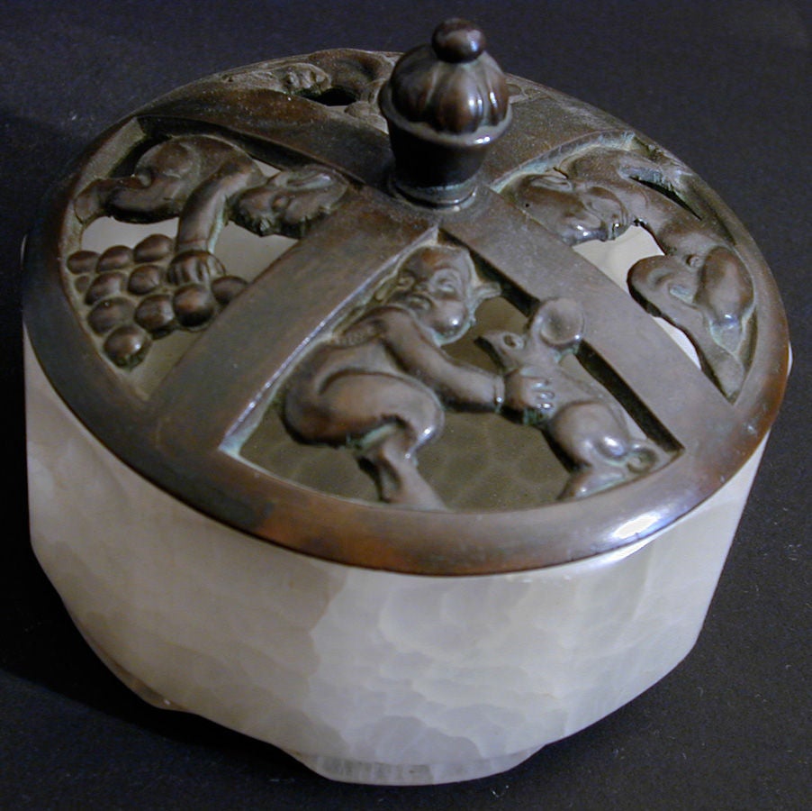 This very rare alabaster box features a bronze lid with four scenes showing baby satyrs.  One scene shows a satyr with a rabbit, another shows a satyr lounging, and two others are shown playing with grapes.  Beautifully modeled and cast in Denmark,