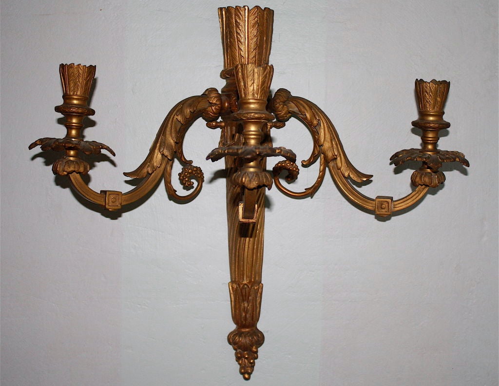 A pair of neoclassical-inspired three-armed ormolu candle sconces. Numbered 3 and 10, they are two of a larger set specified for a Hudson Valley Astor family estate house by a prominent NYC society architect. Details provided to purchaser.