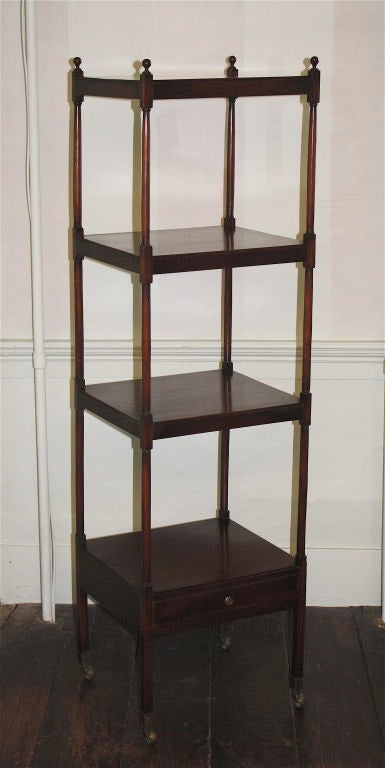 A four-tiered mahogany serving etagere with drawer, on brass casters. De rigueur dining room service staple of the period; useful today for display of fine porcelain or sterling.