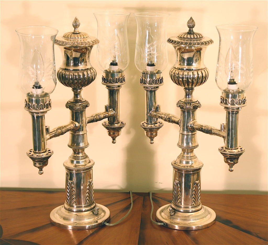 A PAIR of electrified Sheffield 'process' silvered Argand lamps.<br />
Whale or lamp oil was poured into the central urn canisters and<br />
burned for lighting.  Effective on a mantle, sideboard or other<br />
case piece or table where lighting