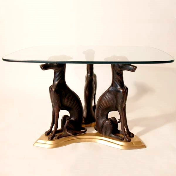 A coffee/cocktail table made by Maitland Smith.  The base modeled in the form of three bronze whippets supporting a rectangular 3/8