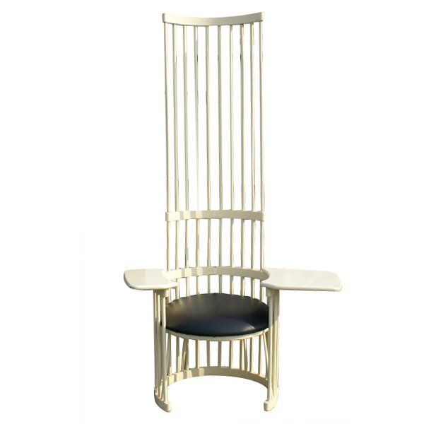 This sculptural chair pulls together a diverse assortment of craft movements from Memphis to Prarie School. A striking and relatively comfortable writing arm chair with platform arms and a barrel shaped back.

White finish with a padded black