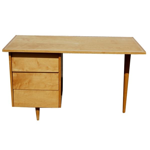 An early desk originally designed by Florence Knoll in 1949. Maple with a single pedestal with three drawers and tapering legs.