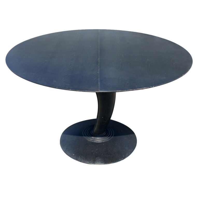 A Mid-Century Modern dining table made by the Italian company Origlia. Ebonized walnut top and column with a weighted steel base. One 17