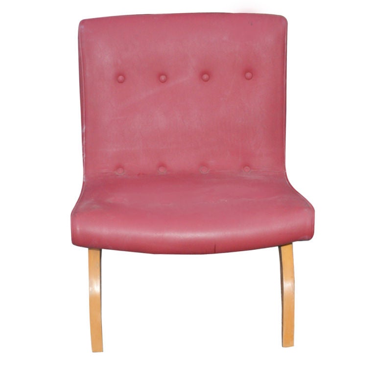 A mid century modern lounge chair designed by Milo Baughman in the early 1950's.  A rare example with arched wooden legs and vinyl upholstery with buttoned details.