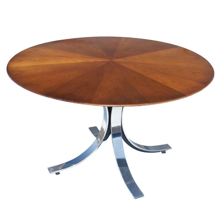 A mid century modern table designed by Osvaldo Borsani for Tecno which could be used for dining or as a small conference grouping and four chairs designed by Bert England and made by Stow Davis.  The table with a sunburst walnut top with knife edge