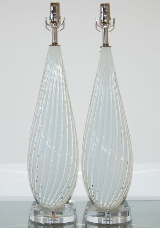 Beautiful white opaline Barbini lamps in a classic tall teardrop shape with swirling vertical ribs and controlled bubbles.  Usually white opaline lamps have a soft blue cast.  Not so with these two.  They are rare in that there is no blue hint -