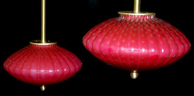 Straight out of the 1960s and coming in for a landing are these Jetson-style Murano lamps! These pendants are a beautiful RASPBERRY SHERBET with loads of controlled bubbles. 

The lamps are newly wired, and mounted with satin-finished solid brass