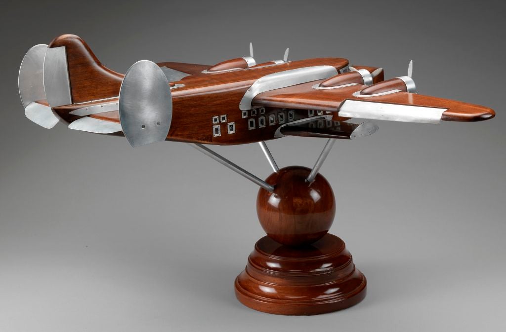 An exceptional and very stylish 1938 boardroom model of the legendary flying-boat with all aluminium detailing, windows and propellers, the tripod mounted on a polished solid mahogany globe, with swept plinth underneath.